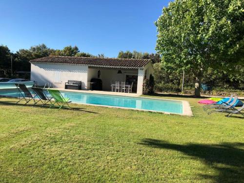 RognesにあるProche Aix-en-Provence maison avec piscine - 10 personnesの庭に椅子とスイミングプールがある家