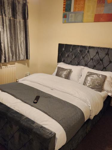 a large bed with a black headboard in a bedroom at Captivating 3-Bed House in Kent in Kent