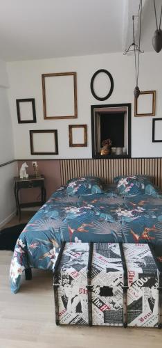 a bedroom with a bed with a comforter on it at Chambres d'hôtes des Princes de Bel Air in Loudun