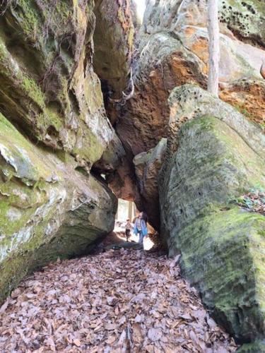 a person standing between two large rock formations at Hocking Hills Cabin-Private Hot Tub, Hiking, Caves in Rockbridge