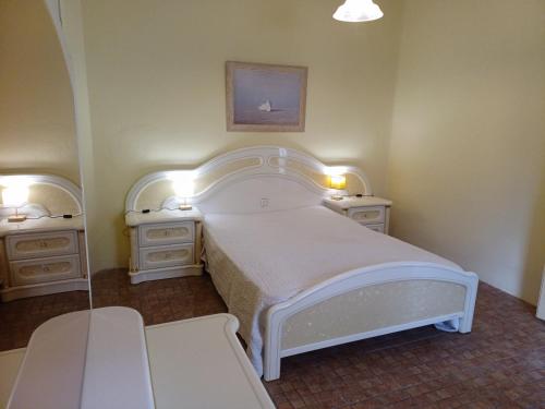 1 dormitorio con 1 cama blanca y 2 mesitas de noche en Kitsch apartment, en Rasquera