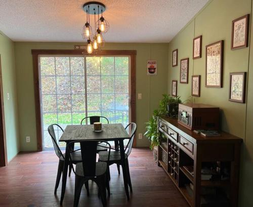 a dining room with a table and chairs and a window at Hocking Hills Cabin-Private Hot Tub, Hiking, Caves in Rockbridge