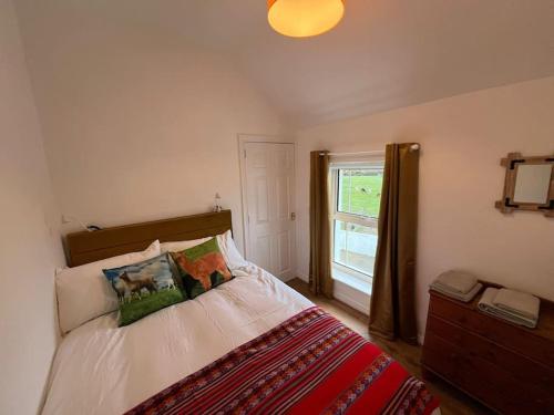 a bedroom with a bed and a window at Alpaca farm 3 bed farmhouse THE ALPACA PLACE in Dromara