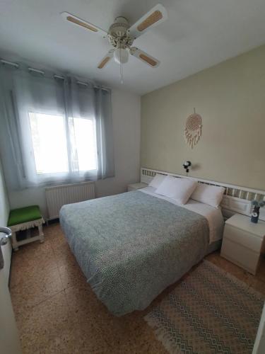 1 dormitorio con 1 cama y ventilador de techo en apartamento Alma, en Salou
