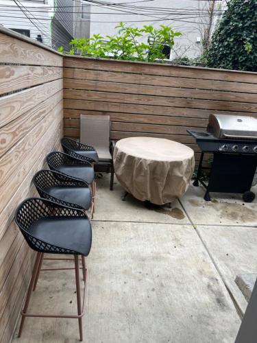 a patio with four chairs and a table and a grill at Luxury Hot Tub Four Seasons in Philadelphia