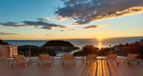 a patio with chairs and a table and a sunset at Villa ROCAZUL in Jávea