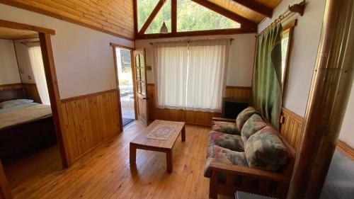 uma sala de estar com um sofá e uma cama em Cabañas con bajada al río em Guayacán