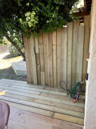 a wooden fence with a garden hose next to it at La bergerie de Cupabia in Serra-di-Ferro