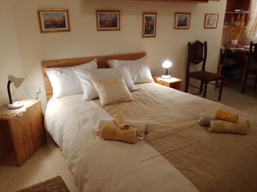a bedroom with a large white bed with two towels on it at Terraced house with stunning view close to Mdina in Rabat