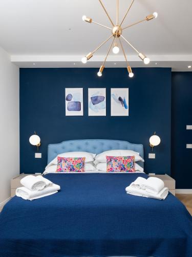 a blue bedroom with a blue bed with two pillows at De Vivo Realty - Regina Vittoria Relais EcoSmart Luxury Home SPA in Vico Equense