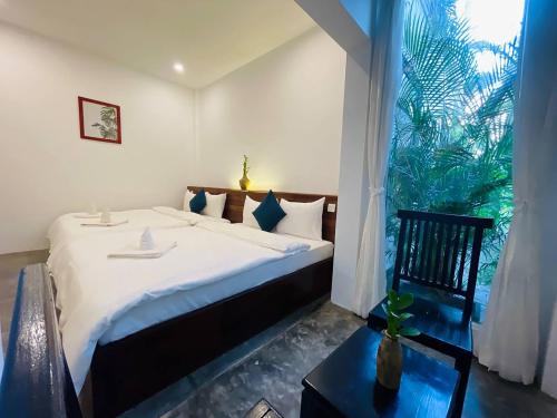 a bedroom with a large bed and a large window at Chhouy Vathna Angkor Boutique in Siem Reap