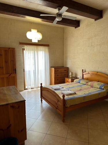 1 dormitorio con cama de madera en una habitación en Nawrat Farmhouse, en Għarb