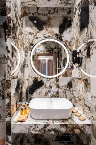 a bathroom with a sink and a mirror at FLOARA DI MUNTE Forest Luxury Suites in Metsovo
