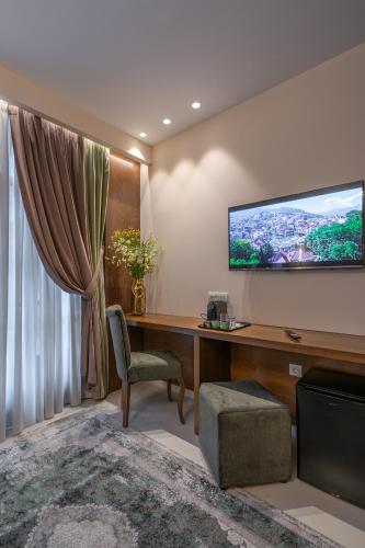 a room with a desk and a television on a wall at FLOARA DI MUNTE Forest Luxury Suites in Metsovo