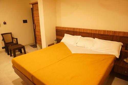 a bedroom with a large yellow bed with a wooden headboard at Shree Mantra Residency and Homestay in Yercaud