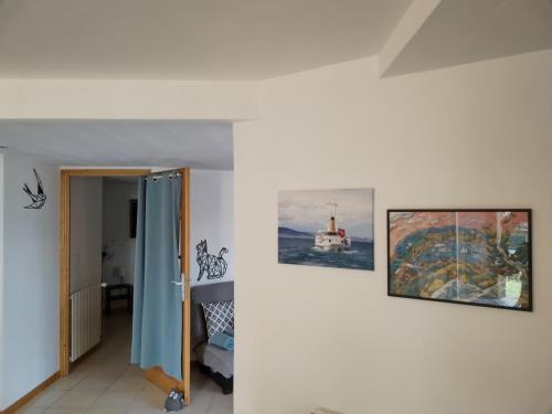 a room with two paintings on the wall at Le Nid du Chat Noir - Gîte La Maison Alvéole in Sciez