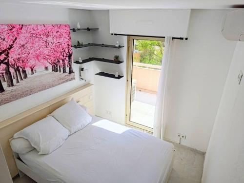 une chambre avec un lit blanc et une fenêtre dans l'établissement Magnifique 2 pièces Piscine Parking Plage à pied Tennis, à Vallauris