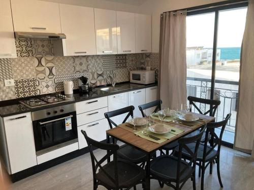 a kitchen with a table and chairs and a kitchen with a view at émeraude au coeur de la marsa plage in La Marsa