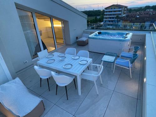 a table and chairs on a balcony with a hot tub at Haus Margarete - Attico Infinity Vista Mare con Jacuzzi - Agenzia Cocal in Caorle