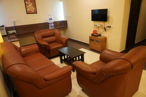 una sala de espera con 2 sillas y TV en Shree Mantra Homestay, en Yercaud