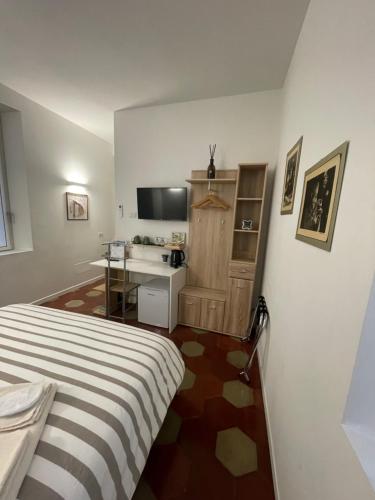 Dormitorio con cama, escritorio y TV en Santa Vincenza - Suite Indipendente en Lovere