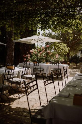 a table with chairs and an umbrella in a garden at Boutique Hotel Boškinac in Novalja