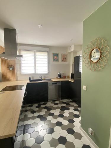 - une cuisine avec un sol en damier noir et blanc dans l'établissement T2 cosy 4 places RDC - jardin, à Lons