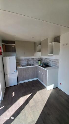 a kitchen with white cabinets and a white refrigerator at Parco Vacanze Italia in Albenga