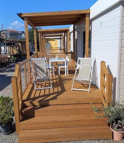 a wooden deck with two chairs and a table at Parco Vacanze Italia in Albenga