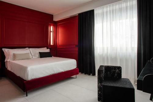 una camera rossa con letto e sedia di Welmy Napoli a Napoli