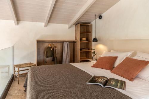 a bedroom with a bed with a book on it at Montesea - Luxury Nature Villas in Vasilikos