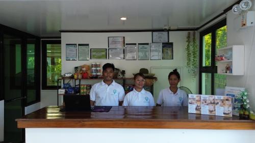 grupa trzech osób stojących przy ladzie w obiekcie General's Hideout Siargao w mieście General Luna