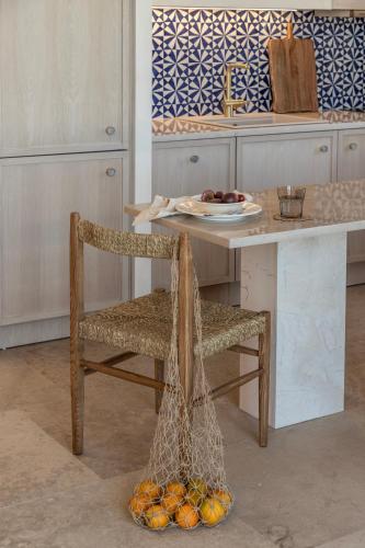 a kitchen with a table with a chair with nets on it at Montesea - Luxury Nature Villas in Vasilikos
