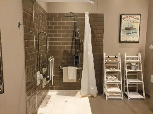 La salle de bains est pourvue d'une douche et d'un rideau de douche. dans l'établissement Titanic Hotel Liverpool, à Liverpool