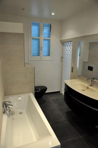 La salle de bains est pourvue d'un lavabo noir et blanc et de toilettes. dans l'établissement Villa de charme 5 pièces vue mer, à Antibes
