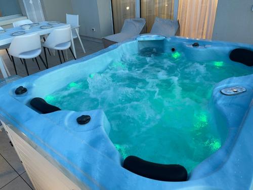 a jacuzzi tub with green lights in a restaurant at Haus Margarete - Attico Infinity Vista Mare con Jacuzzi - Agenzia Cocal in Caorle