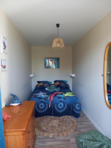 Schlafzimmer mit einem Bett und einem Holztisch in der Unterkunft Gîte au centre des plages du débarquement in Isigny-sur-Mer