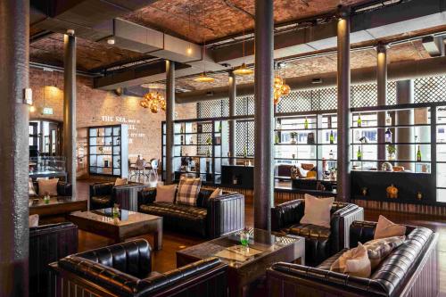 a bar with leather couches and tables at Titanic Hotel Liverpool in Liverpool