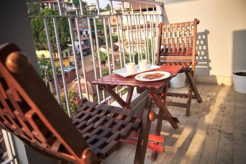 een houten tafel met een bord eten op een balkon bij Malini Homes Unit - 2 in Guwahati