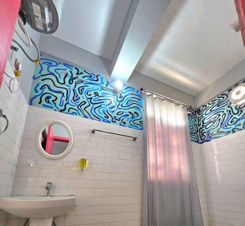 een badkamer met een blauw en wit patroon op de muur bij Malini Homes Unit - 2 in Guwahati
