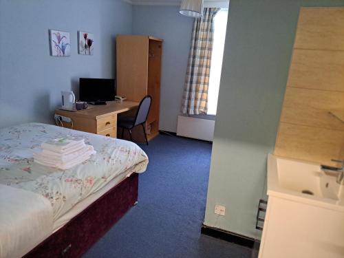 a bedroom with a bed and a desk with a computer at Luther King House in Manchester