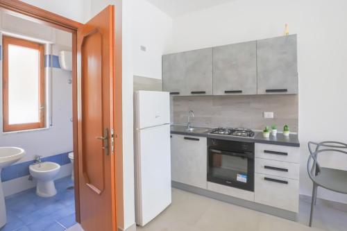 een keuken met een witte koelkast en een spoelbak bij Paolino Housing in Paestum