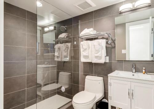 a bathroom with a toilet and a sink and a mirror at Plunge Beach Resort in Fort Lauderdale