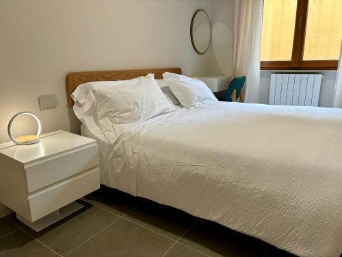 a bedroom with a white bed with a night stand at Camere di Bianca in Foligno