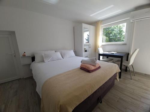 a bedroom with a bed and a desk and a window at Eden apartment in Kornić