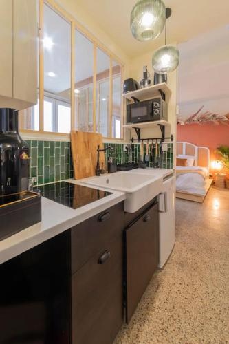 une cuisine avec un évier et un plan de travail dans l'établissement Un petit nid douillet, à Montpellier