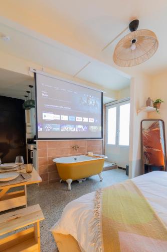 une chambre avec un grand écran avec une baignoire dans l'établissement Un petit nid douillet, à Montpellier
