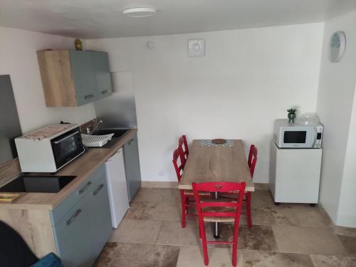 a small kitchen with a table and a red chair at Le Tilleul in Sarlat-la-Canéda