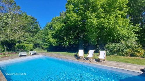 una piscina con tre sedie a sdraio accanto di Domaine de Cachaou Logis du Pujeau sauna & spa piscine chauffée a Salles