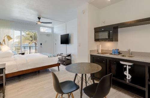 a hotel room with a bed and a table and chairs at Plunge Beach Resort in Fort Lauderdale